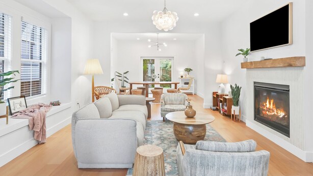 A modern living room with a fireplace, a sofa, a coffee table, and a dining area. - Old-Portland Charmer in the Alphabet District (Portland)