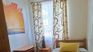 Ein Schlafzimmer mit einem hölzernen Bett, einem Schreibtisch und einem Stuhl.
