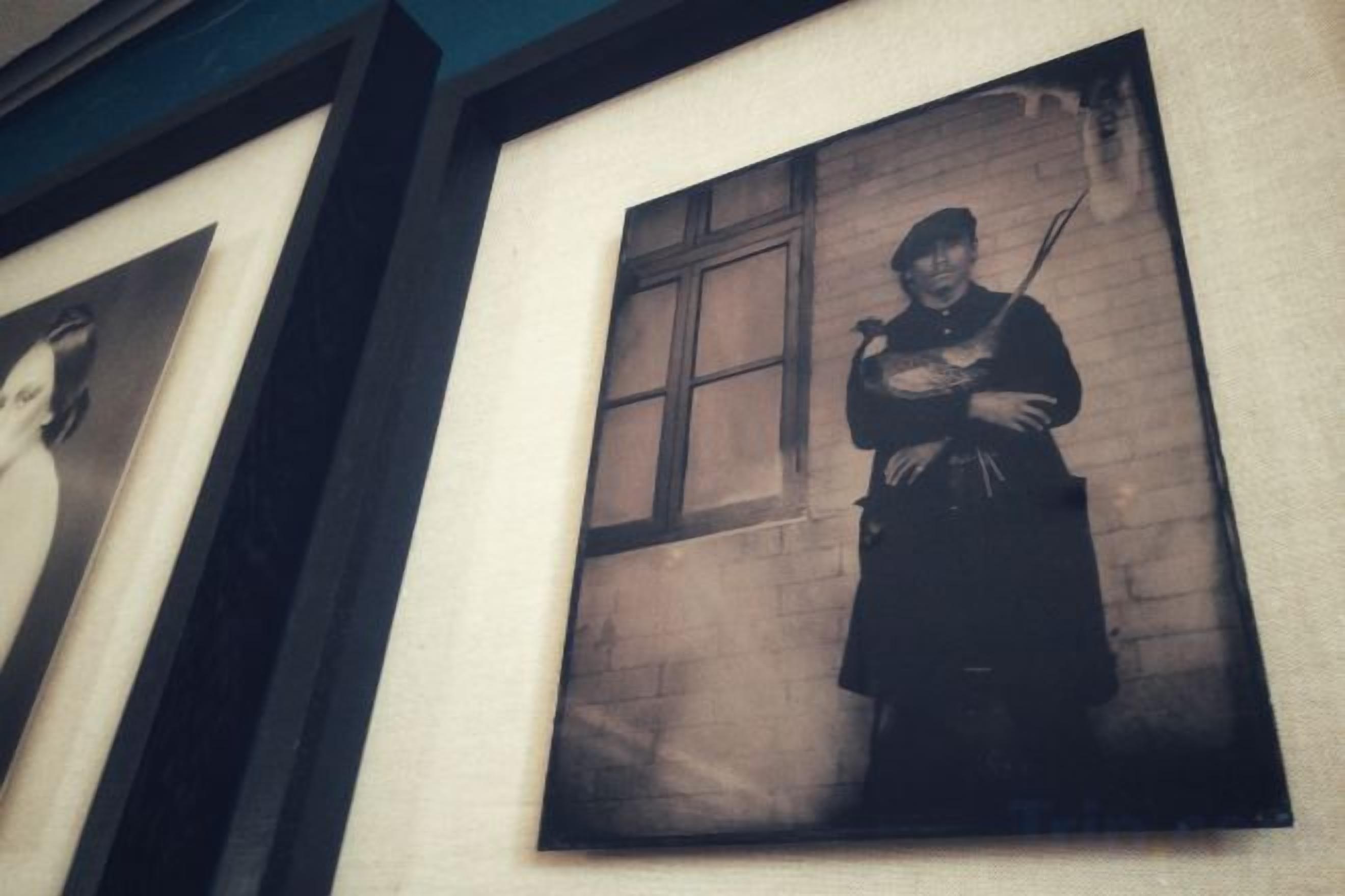 A framed photograph of a person standing by a window.
