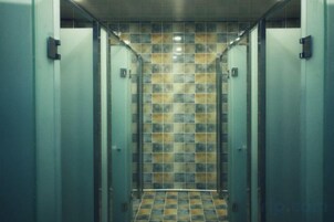 Un ascensor con pared de azulejos y puertas metálicas.