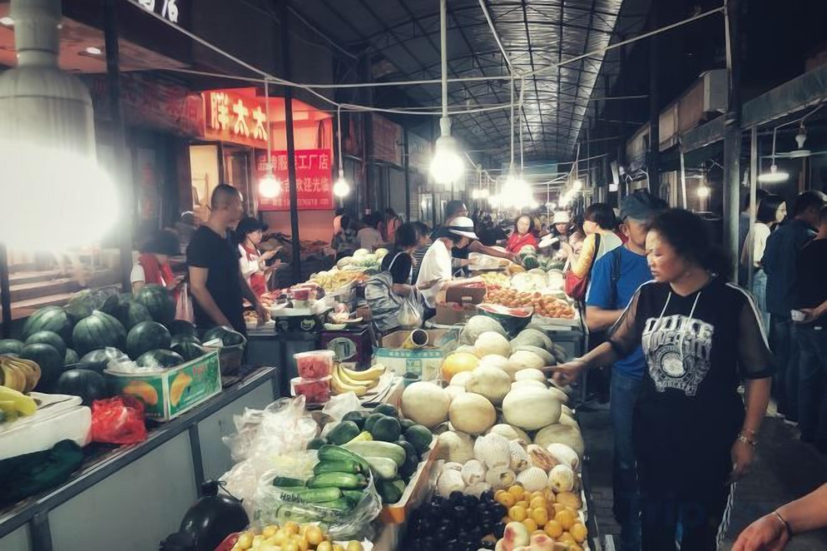 A market with various stalls selling fruits and vegetables.