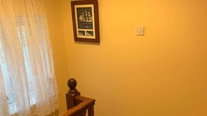 A staircase with wooden railings and a patterned rug at the bottom. - Room-king Bed With Shared Bath (Dublin)