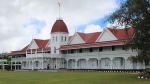 Un edificio grande de estilo colonial blanco con techo rojo y una cúpula destacada.