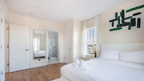 A bedroom with a large bed, a walk-in closet, a bathroom with a shower, and a window with curtains. - 3BR Prime Luxury near NYC w Arcade Room (Yonkers)