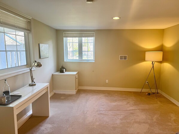 A room with a desk, a lamp, a radiator, and a window.