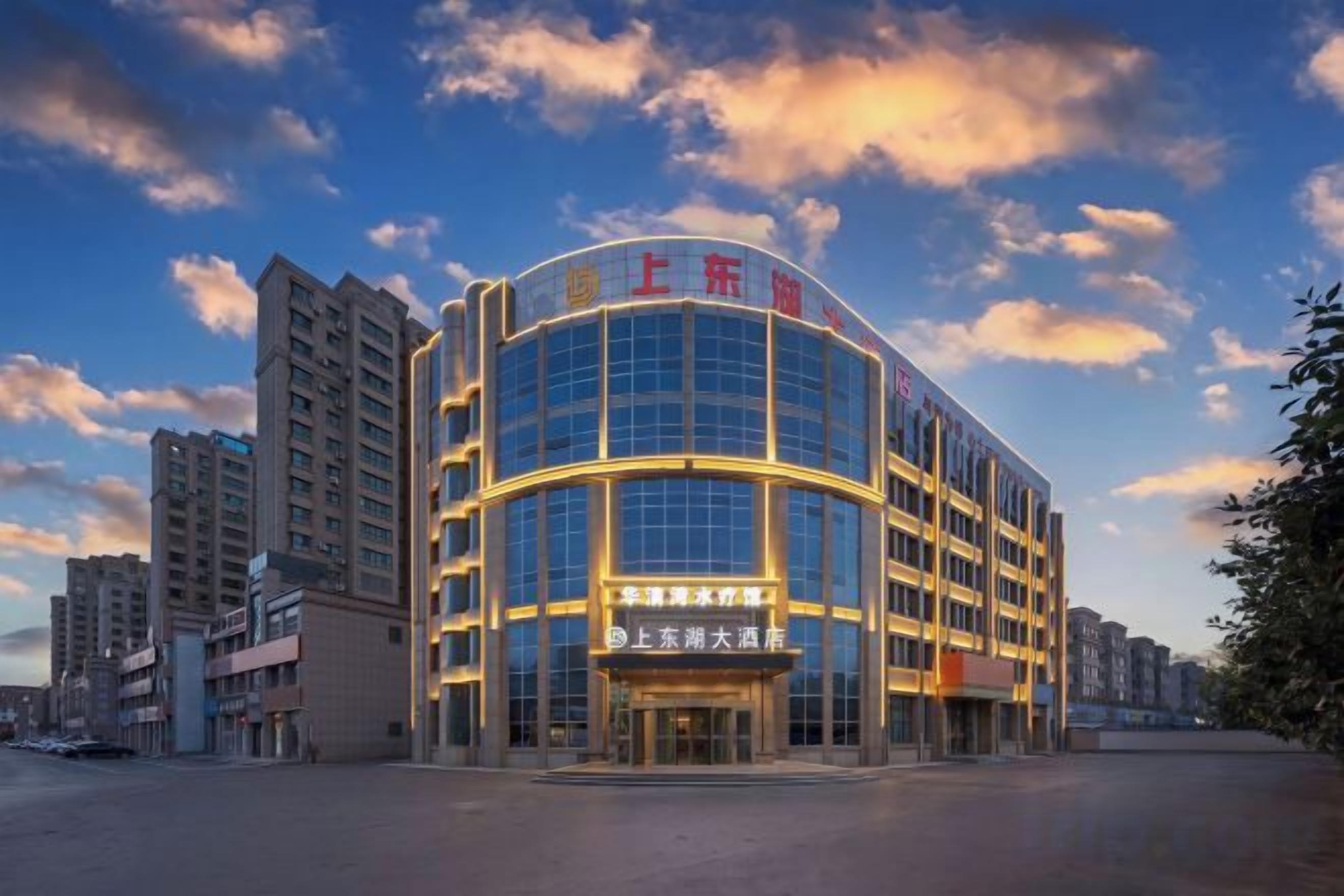 A modern hotel with a curved facade, multiple floors, and a prominent entrance.