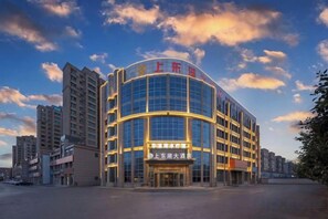 A modern hotel with a curved facade, multiple floors, and a prominent entrance. - Shangdong Lake Hotel (Kuytun)