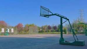 Un terrain de basket-ball en plein air avec un panier de basket vert.