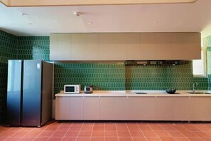 A kitchen with a refrigerator, microwave, and a sink.