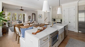 A modern kitchen with white cabinetry, stainless steel appliances, and a central island.