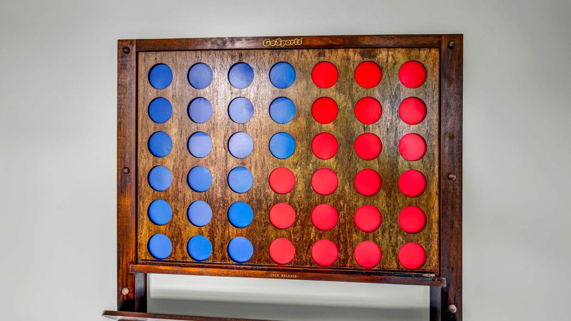 A GoSports Go game board with a wooden frame and a coin release mechanism.