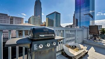 A rooftop grill with a city skyline in the background.