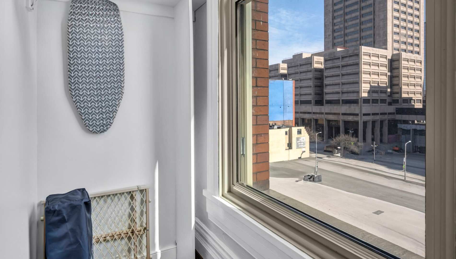 A room with a large window, a patterned wall hanging, and a radiator.