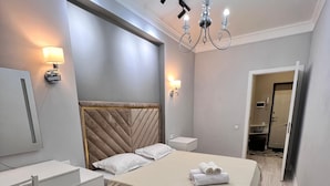 A modern bedroom with a bed, bedside table, chair, desk, and a mirror. - World Retreats (Almaty)