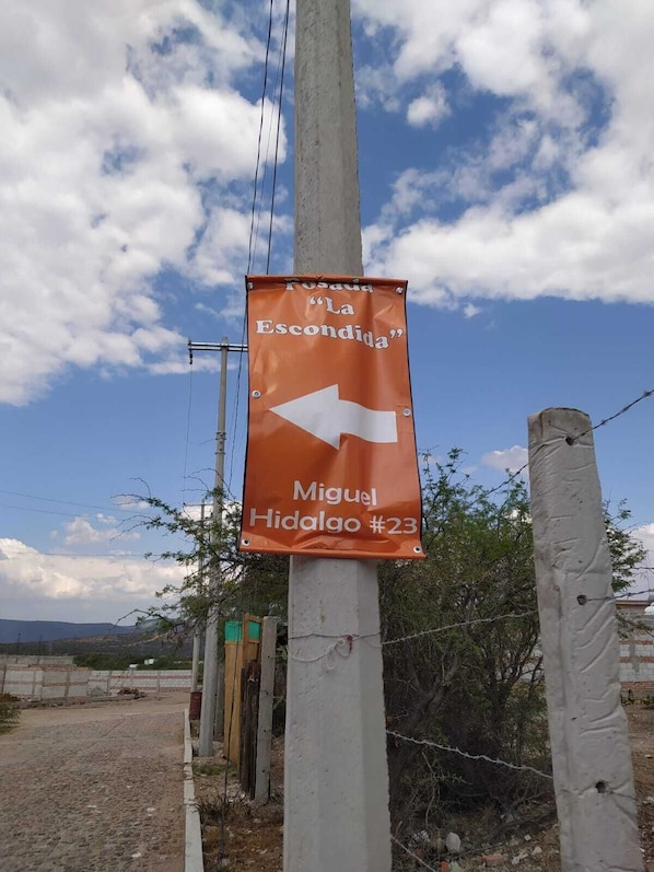 A directional sign with an arrow pointing left, indicating a route or destination. - Posada La escondida (San Juan del Rio)