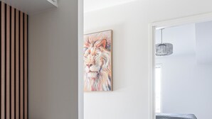 A modern bedroom with a bed, a nightstand, a painting, and a wooden slat wall. - Luxurious 1BR Penthouse with Balcony (Tampere)