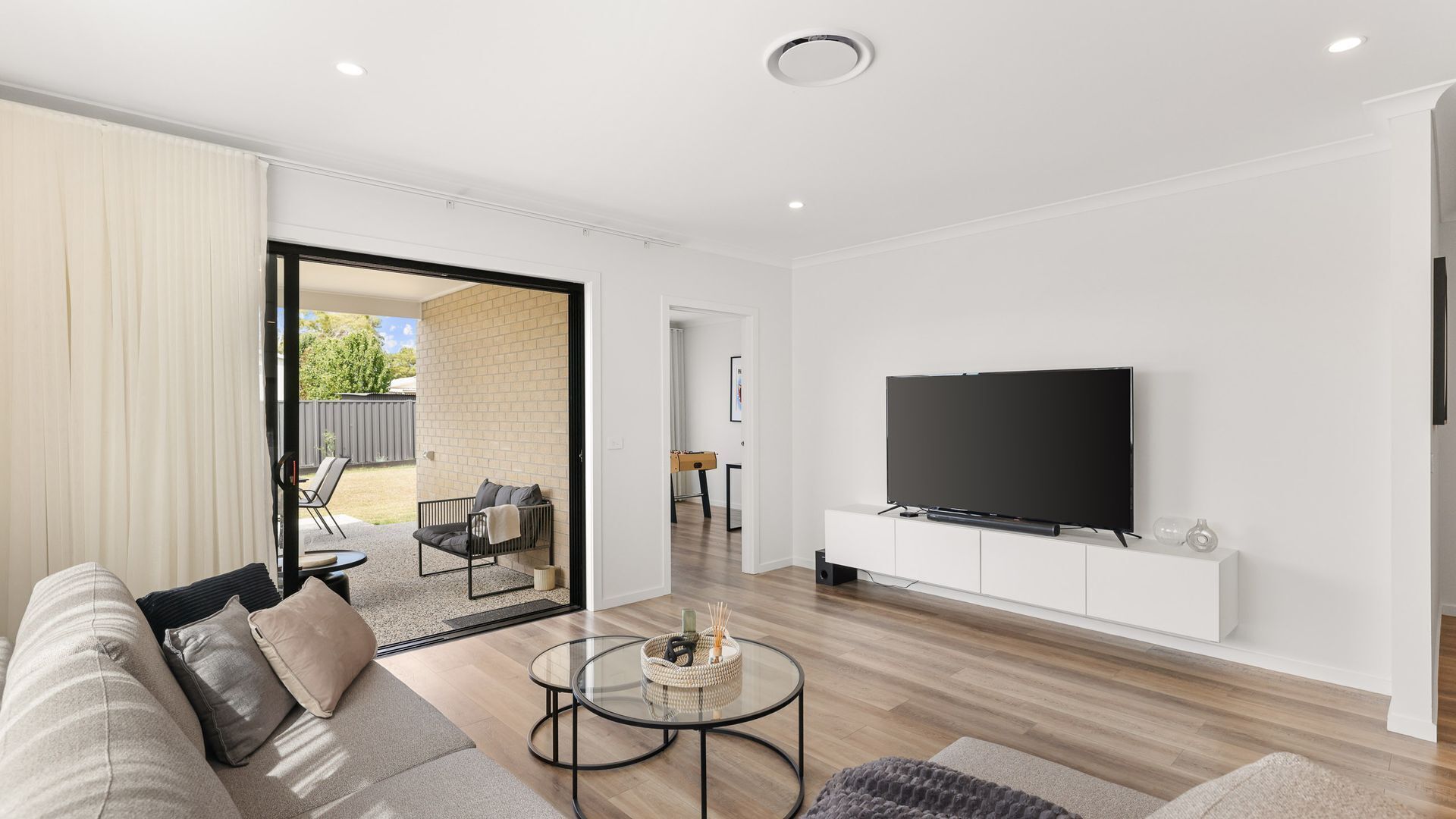 A modern living room with a sofa, coffee table, and TV.