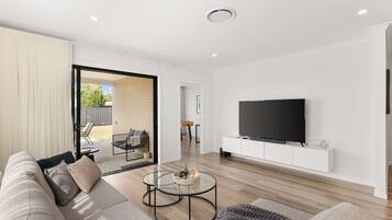 A modern living room with a sofa, coffee table, and TV.