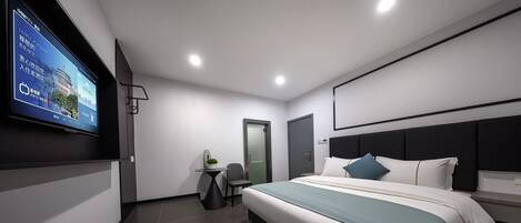 Una habitación de hotel moderna con una cama grande, un televisor de pantalla plana montado en la pared, una mesita con una silla y una puerta.