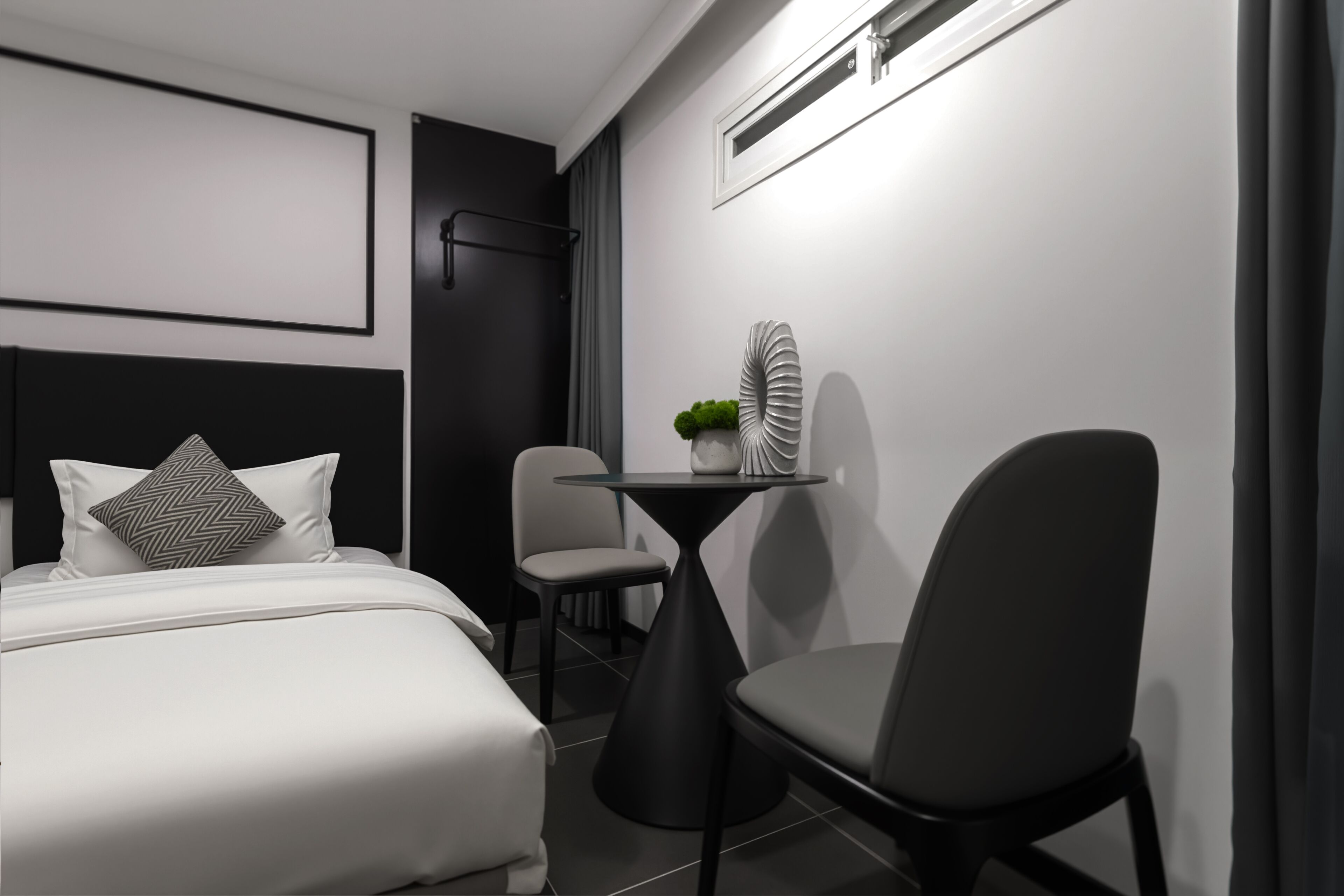 A modern bedroom with a bed, a small table, and a chair.