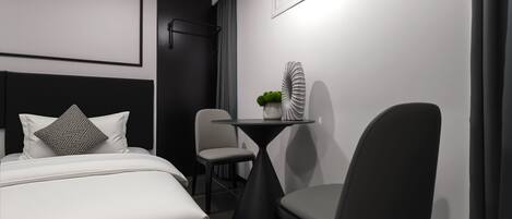 A modern bedroom with a bed, a small table, and a chair.