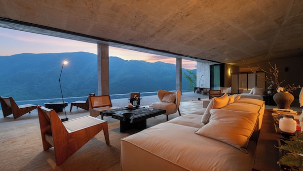 A modern living room with a large window overlooking a mountainous landscape. - The Mountain Route (Guang'an)