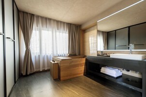 Un baño moderno con tocador de madera, un lavamanos grande y una zona de ducha integrada.