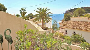 A coastal town with buildings, palm trees, and a view of the sea.