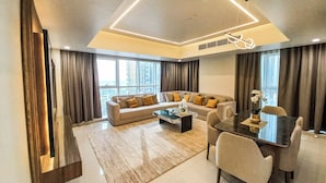 A modern living room with a sofa, coffee table, and dining area. - Apartment 2BD,Royal Home , Deluxe, Beach View, Abu Dhabi (Abu Dhabi)