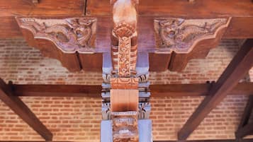 Una estructura de madera con intrincados grabados y un fondo de pared de ladrillo.