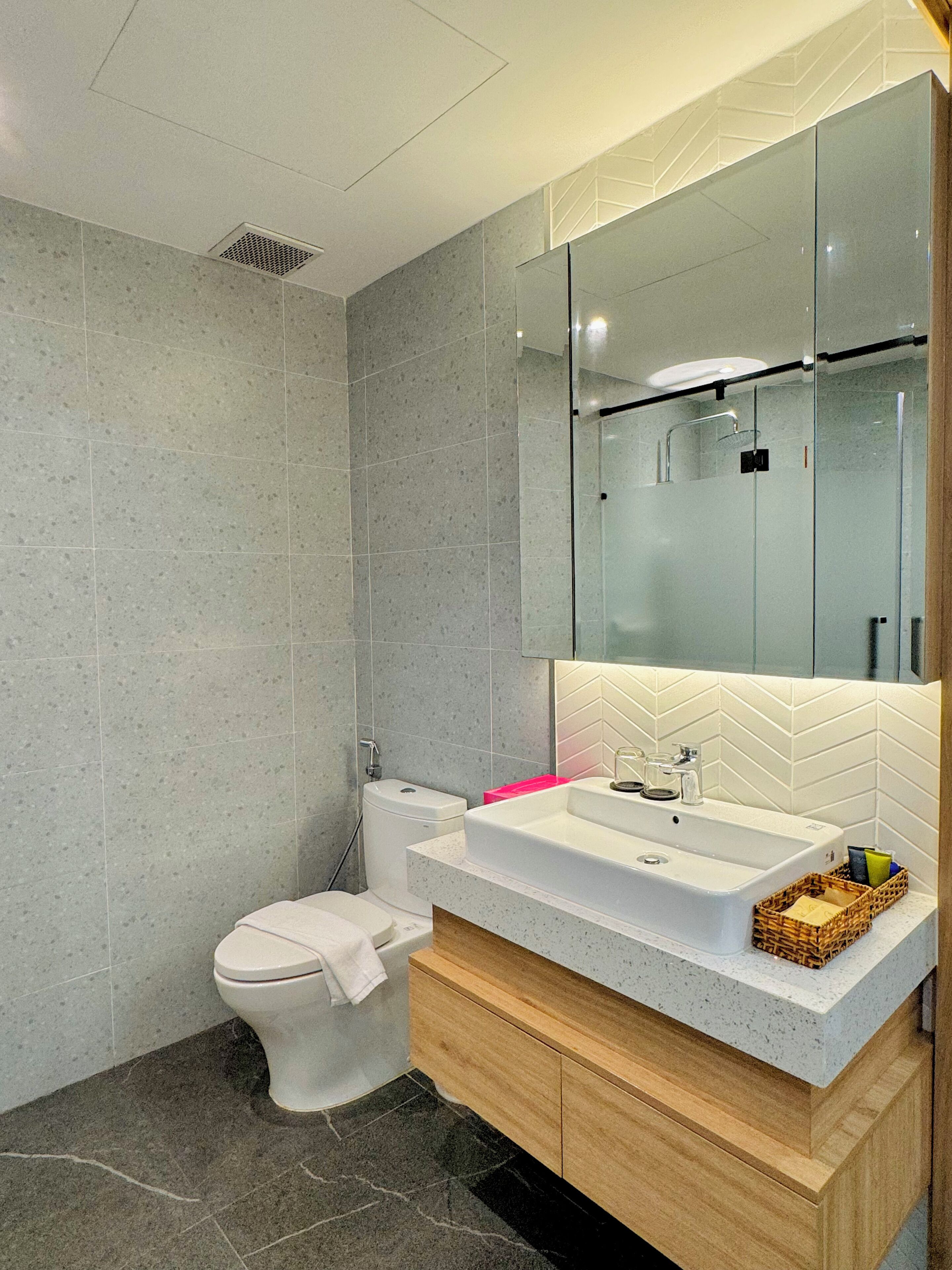 A modern bathroom with a toilet, sink, and shower.