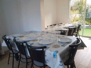 Comedor con mesas dispuestas para cuatro, sillas y vistas al exterior a través de amplios ventanales.