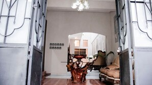 A spacious entryway with a wooden coffee table, a sofa, and a chandelier. - Casa Márquez (Leon)