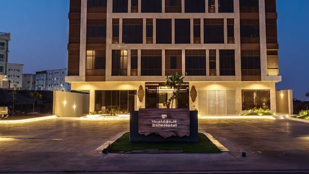 Een modern hotelgebouw met een opvallend bord bij de ingang.