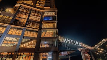 Un hotel moderno con varios pisos, amplias ventanas y una entrada destacada.