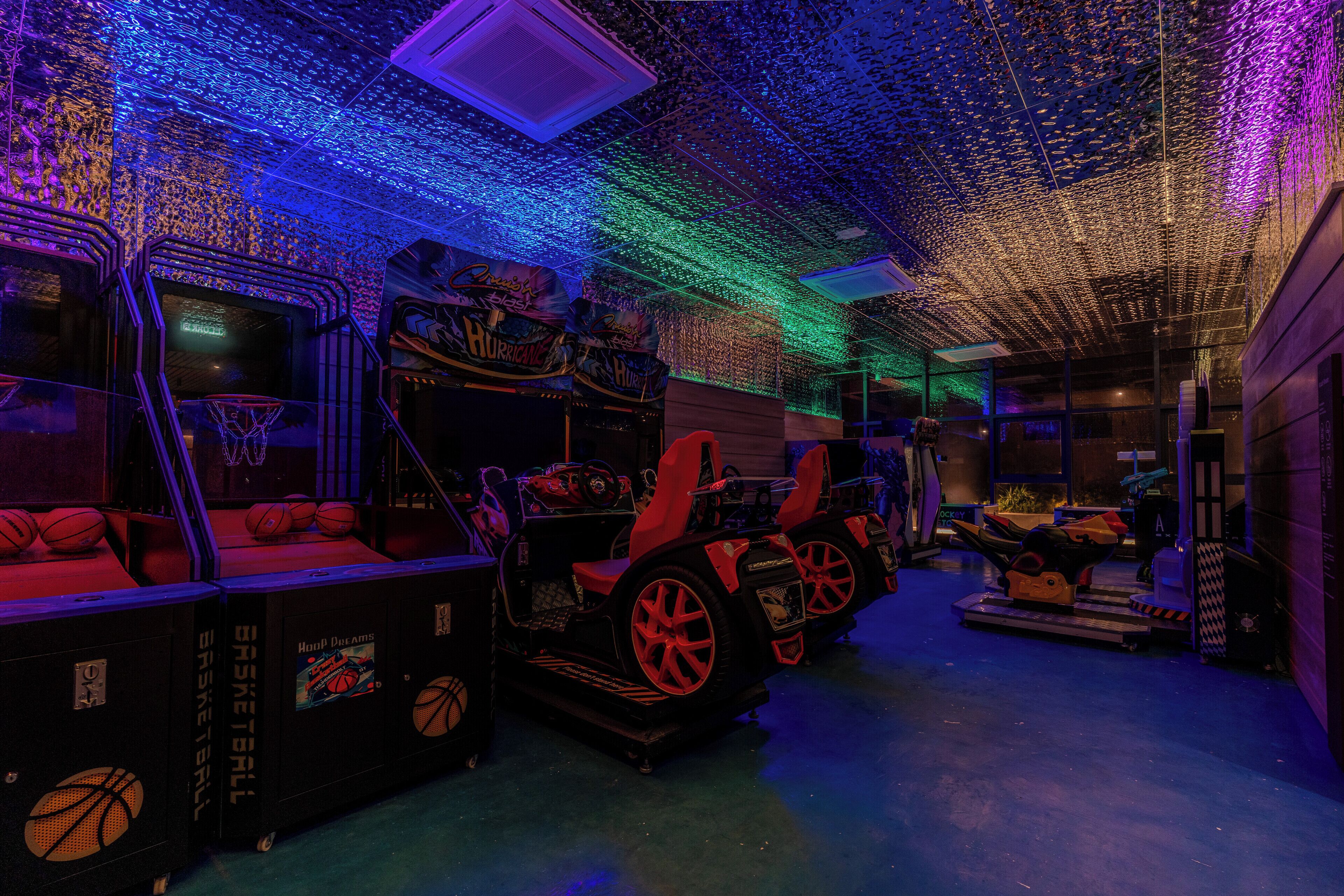 A basketball-themed room with arcade games, a basketball hoop, and a car-themed play area.