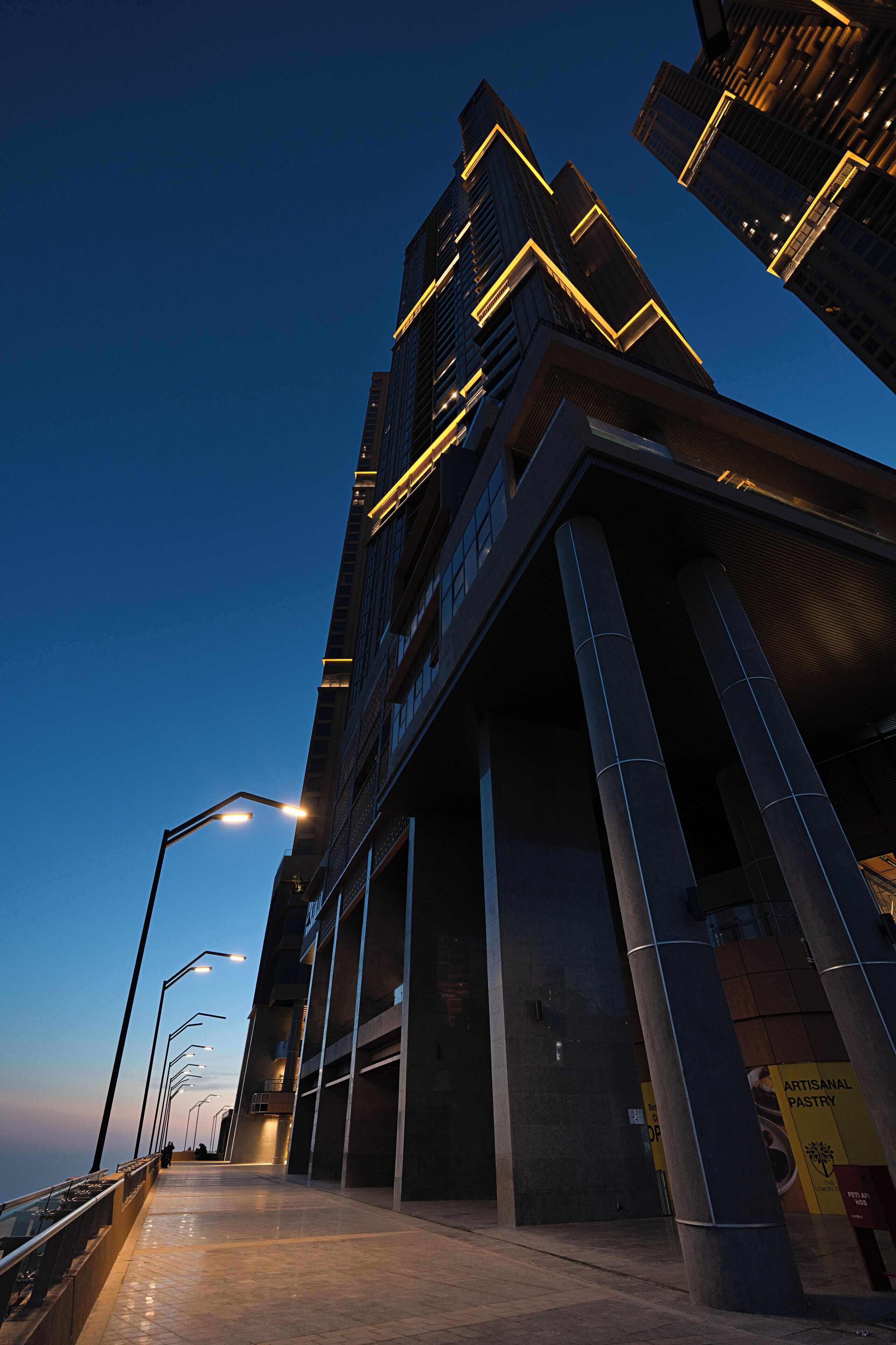 A modern building with a glass facade and a pedestrian walkway.