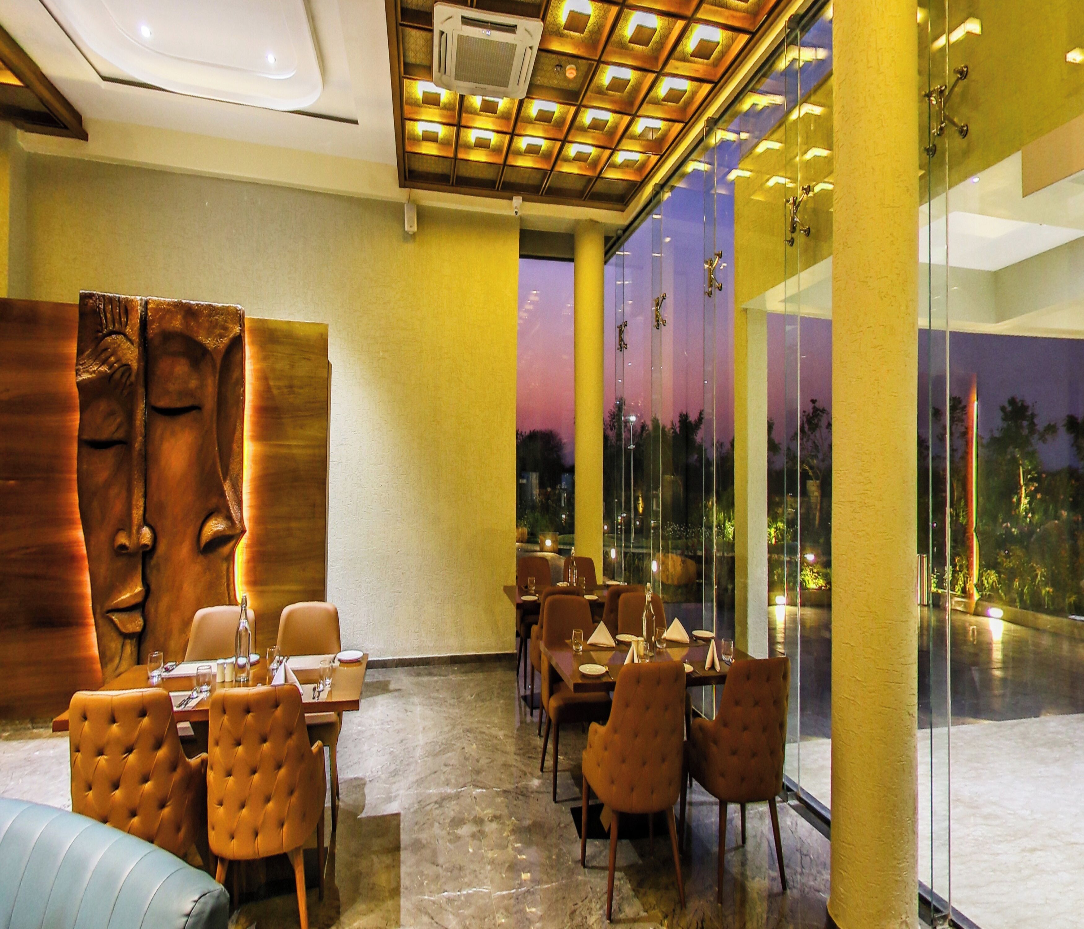 Un restaurante con suelo de mármol, sillas de madera e iluminación empotrada en el techo.