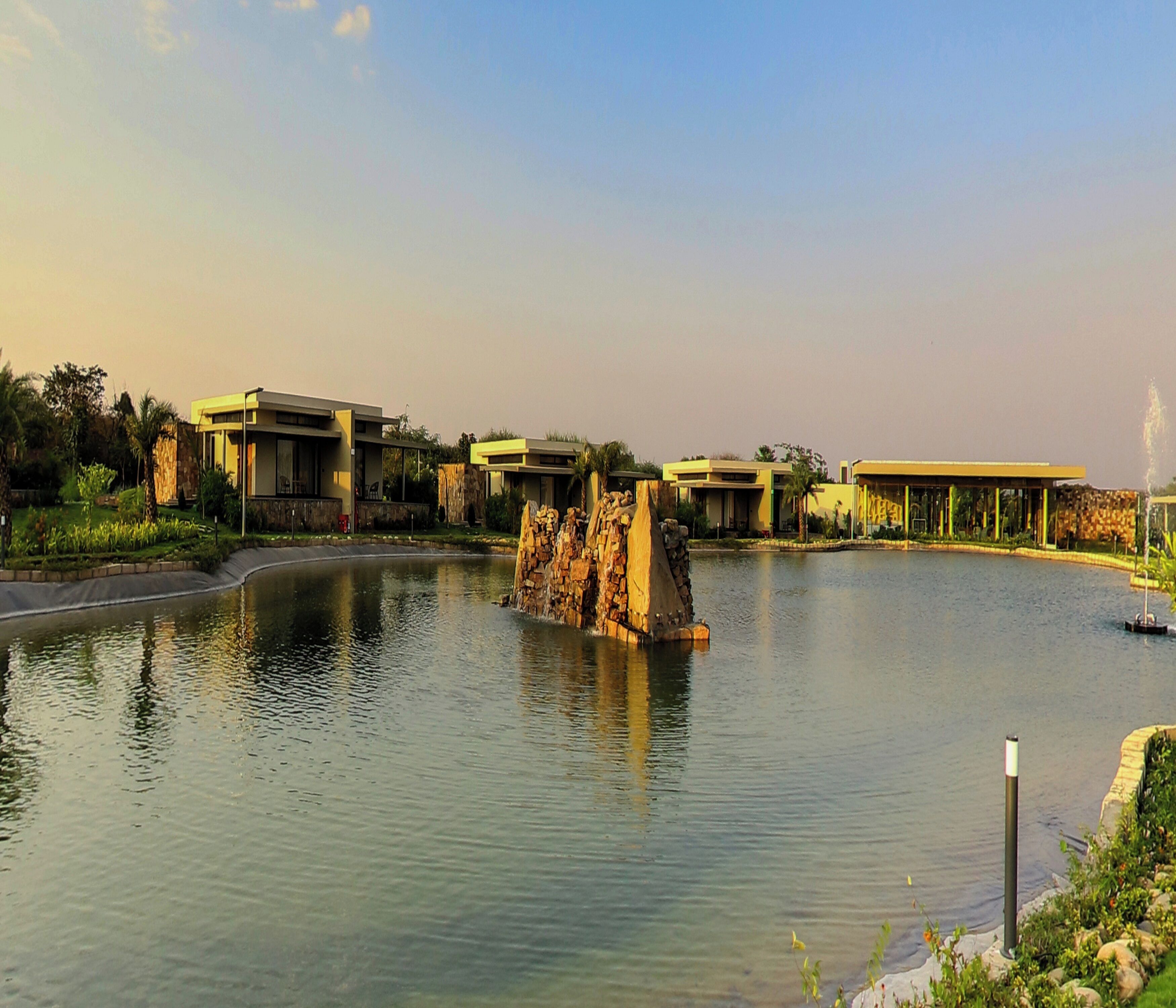 Ein Resort mit modernen Gebäuden, einer zentralen Wasserspiele und einem angelegten Garten.