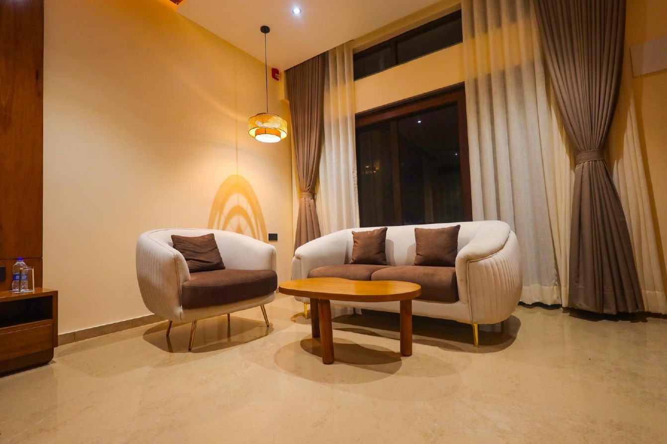 Uma sala de estar moderna com dois sofás, uma mesa de centro e um lustre.
