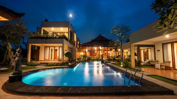 Un hôtel moderne doté d’une piscine, d’un espace extérieur aménagé et dont l’arrière-plan est constitué d’un bâtiment traditionnel.