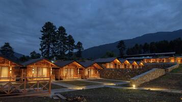 Cabins line a stone pathway, offering a serene mountain retreat.