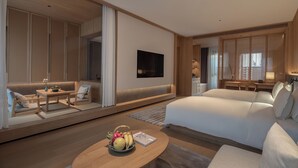 A modern hotel room with a large bed, a sofa, a dining area, and a TV. - Huangshan Misty Rain Resort Hotel (Huangshan)