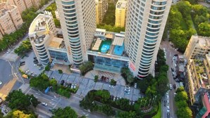 A high-rise building with a rooftop pool, surrounded by other residential buildings and greenery. - Xiamen Mingfa International Hotel (Convention Center Huandao Road Branch) (Xiamen)