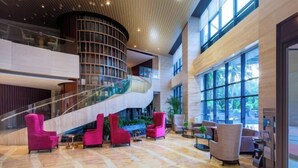 A spacious lobby with a curved staircase, comfortable seating areas, and large windows providing natural light. - Xiamen Mingfa International Hotel (Convention Center Huandao Road Branch) (Xiamen)
