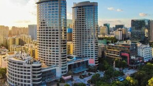 A high-rise building with a modern architectural design, featuring multiple floors and a prominent glass facade. - Xiamen Mingfa International Hotel (Convention Center Huandao Road Branch) (Xiamen)