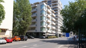 Ein mehrstöckiges Hotel mit Balkonen, einem Parkplatz und Blick auf die Straße.