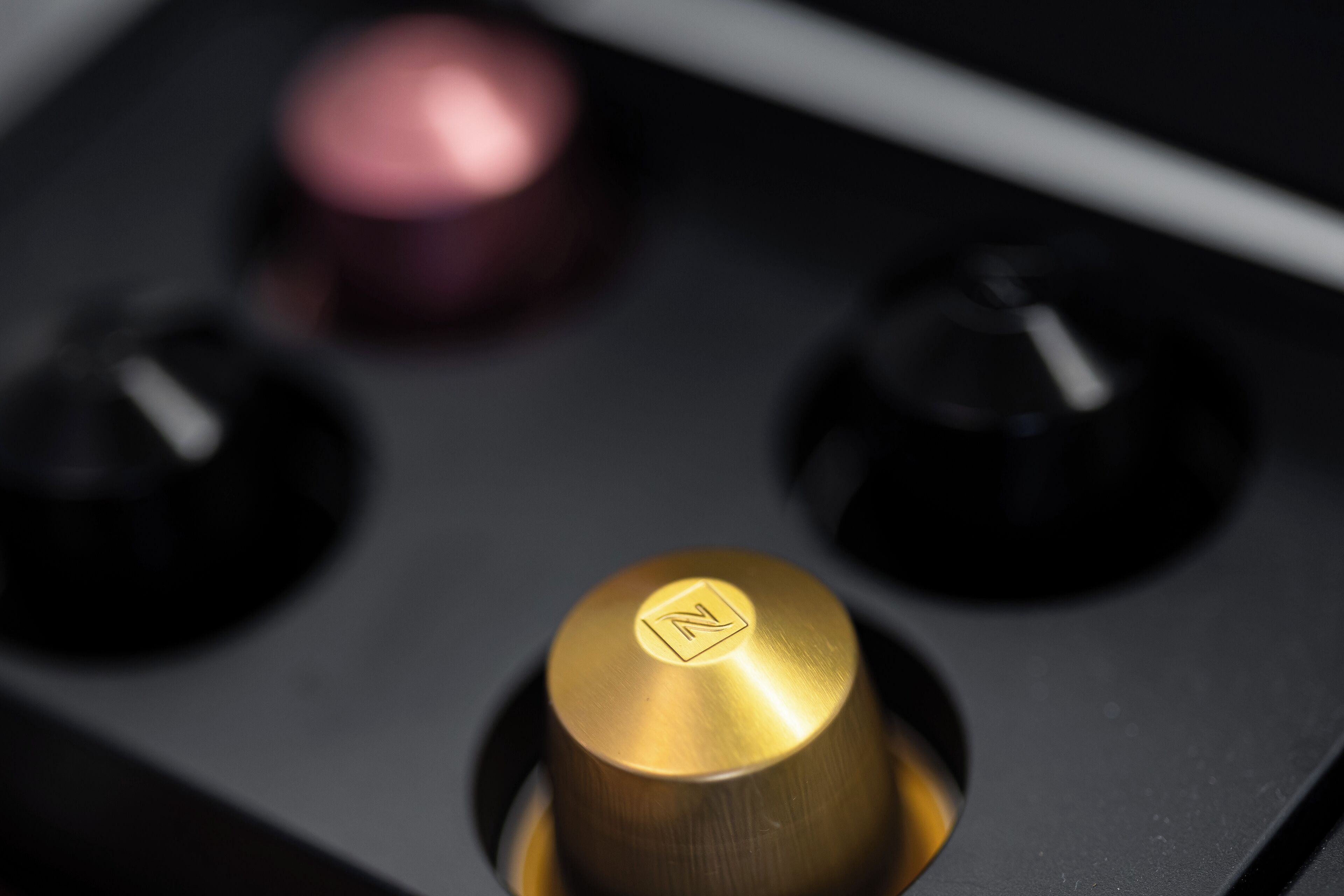A close-up of a control knob with a gold finish and a letter 'N' emblem.