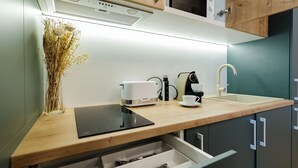 Eine moderne Küche mit einer Holzausziehtafel, einem Toaster, einer Kaffeemaschine und einem Spülbecken.
