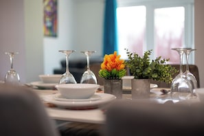 A dining table with multiple wine glasses, a white bowl, and small potted plants.